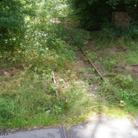 Bild 2: Einfahrt in den Oelhof an der Robert Koch Str., 2014. Auf jeder Seite des Gleiskörpers sind die Fundamente der Tore noch erhalten, Foto Bendler.